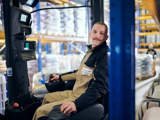 Ein Mann fährt einen Gabelstapler im SCHAUMANN-Werk