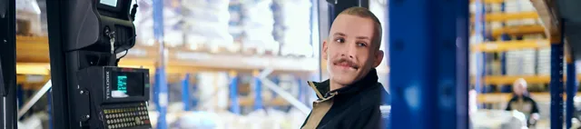 Ein Mann fährt einen Gabelstapler im SCHAUMANN-Werk